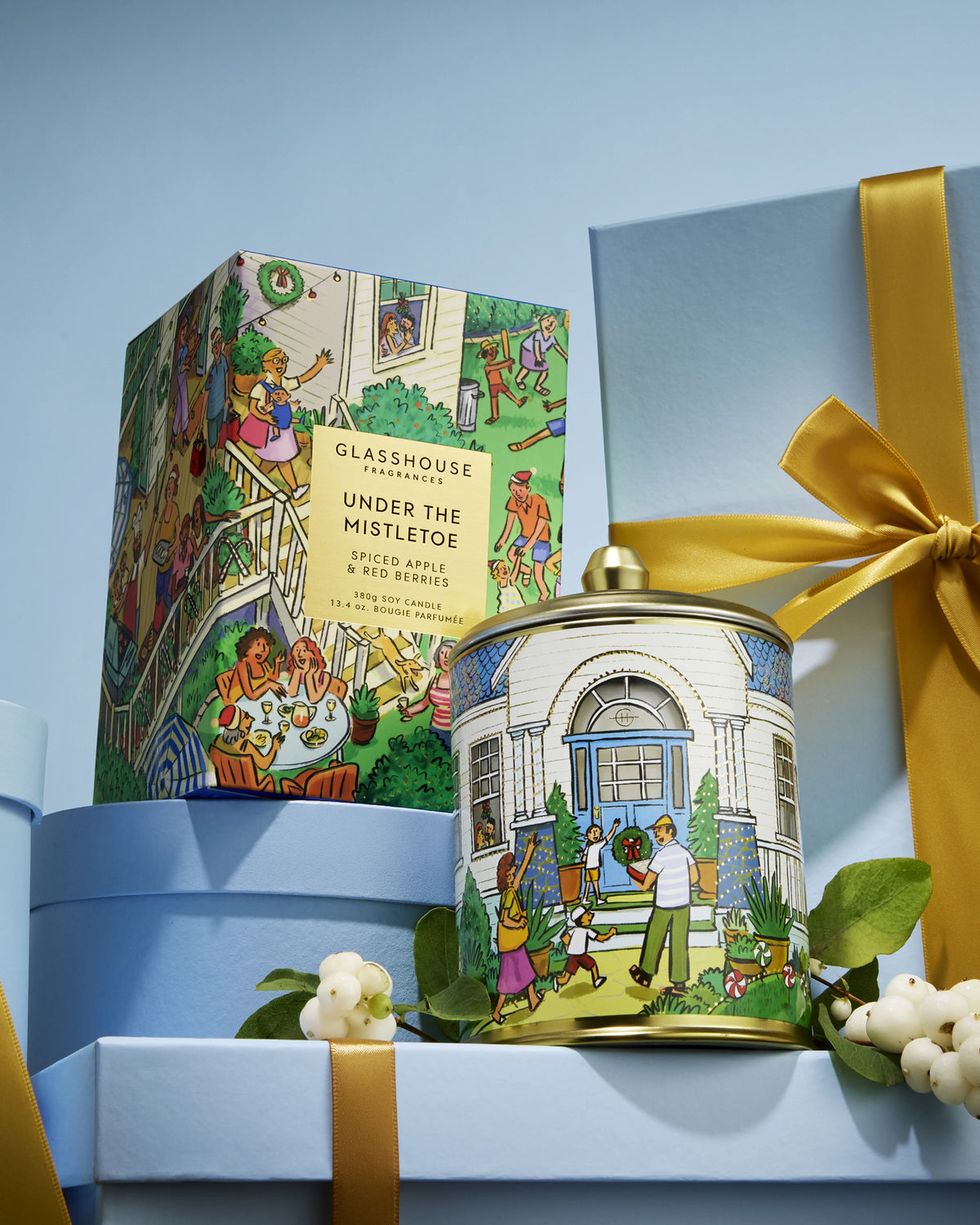 Glasshouse Fragrances Under the Mistletoe 380g Candle and box styled on blue gift boxes with mistletoe