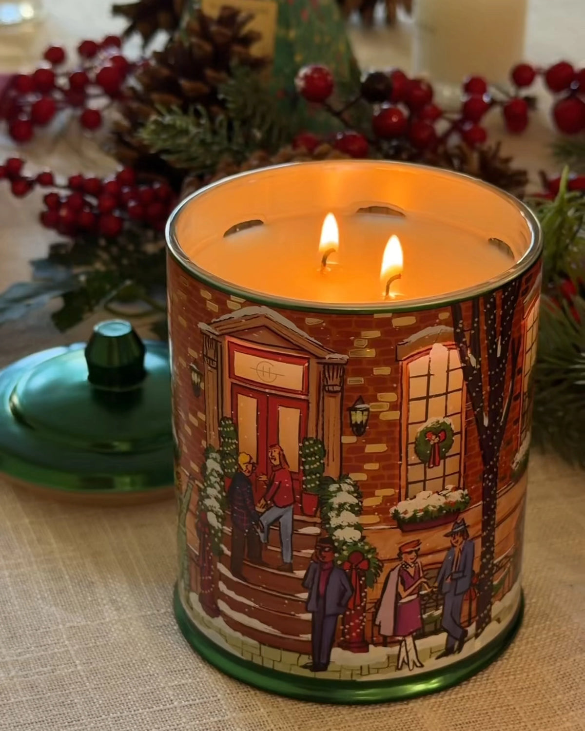 Glasshouse Fragrances Winter Wonderland Candle lit with two flames on a festive table