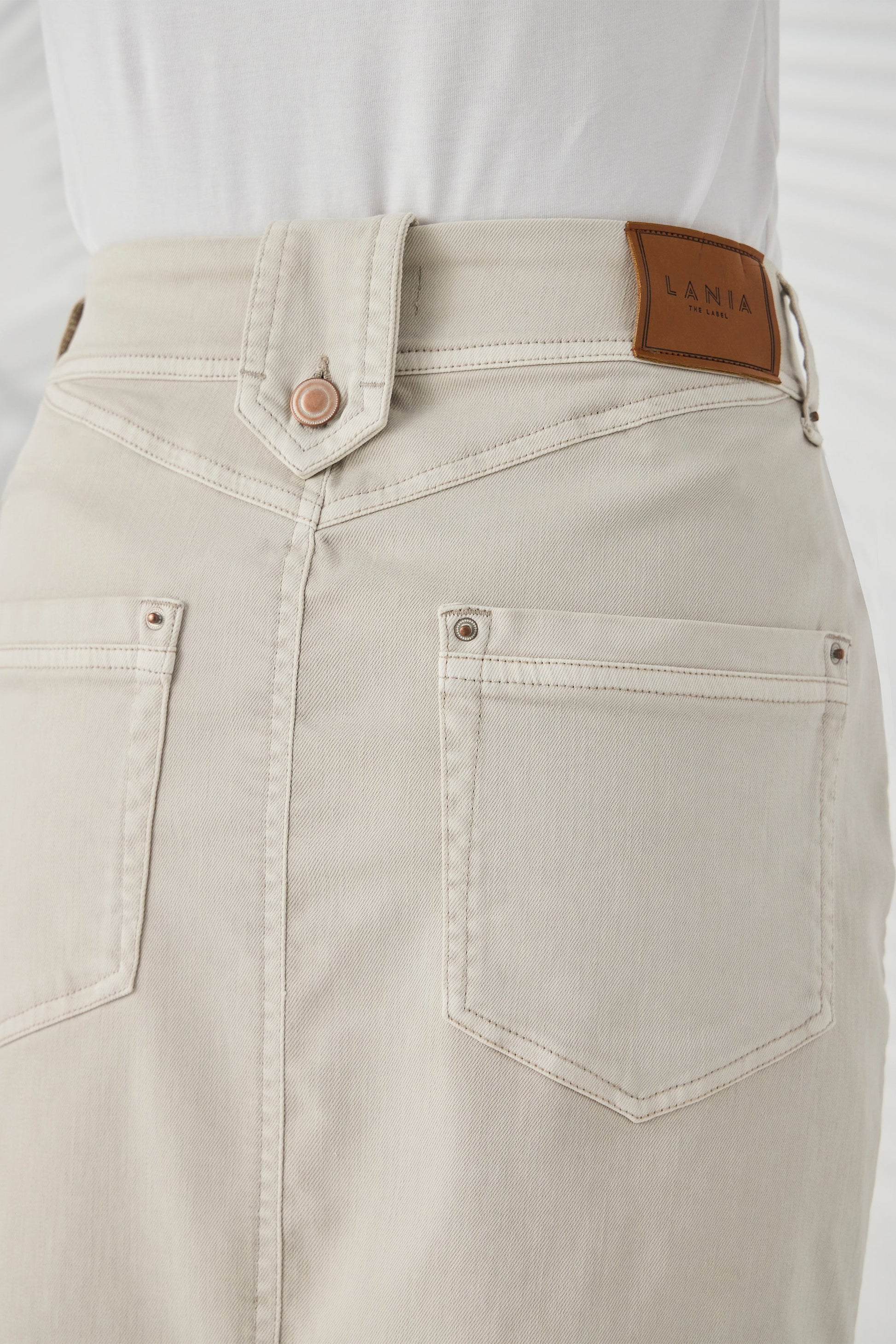 Close-up of the waistband and back pocket detailing on the Lania Ryder Skirt in Almond