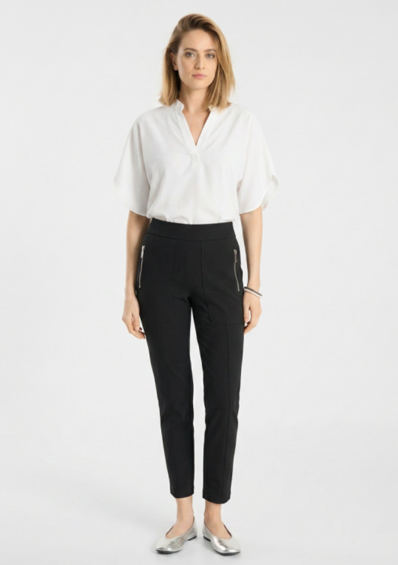 Model wearing Raffaello Rossi Corry Hightech Jersey Pant in Black with a white top and silver flats